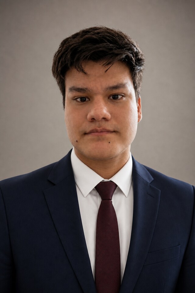 Retrato profesional de Jhon Steven Alvarez Ruiz con traje oscuro y fondo neutro